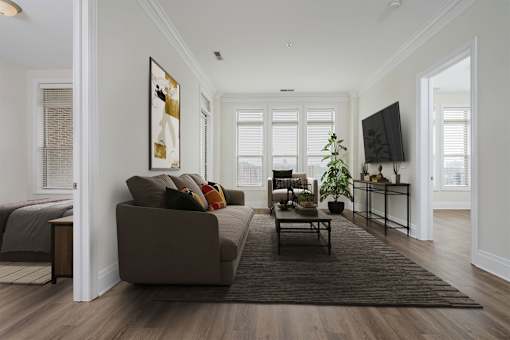 A living room with a brown couch and a rug.