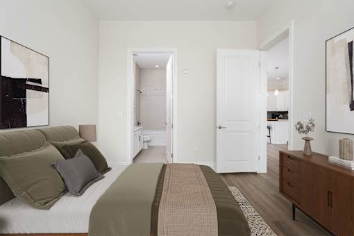 A bedroom with a bed, nightstand, and a painting on the wall.