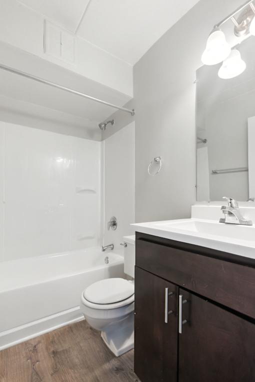 A white toilet sits in a bathroom next to a sink.