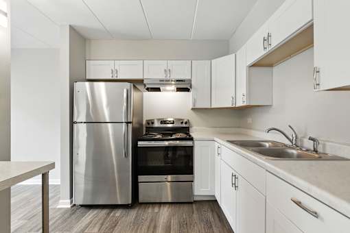 A modern kitchen with a stainless steel refrigerator and oven.