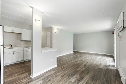 A kitchen with white cabinets and a refrigerator.
