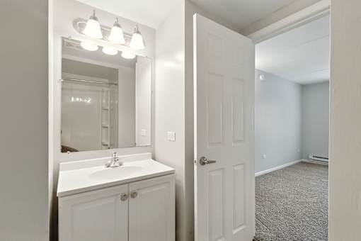 A bathroom with a sink, mirror, and lights.