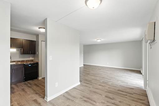 A room with a kitchen area and a dining table.