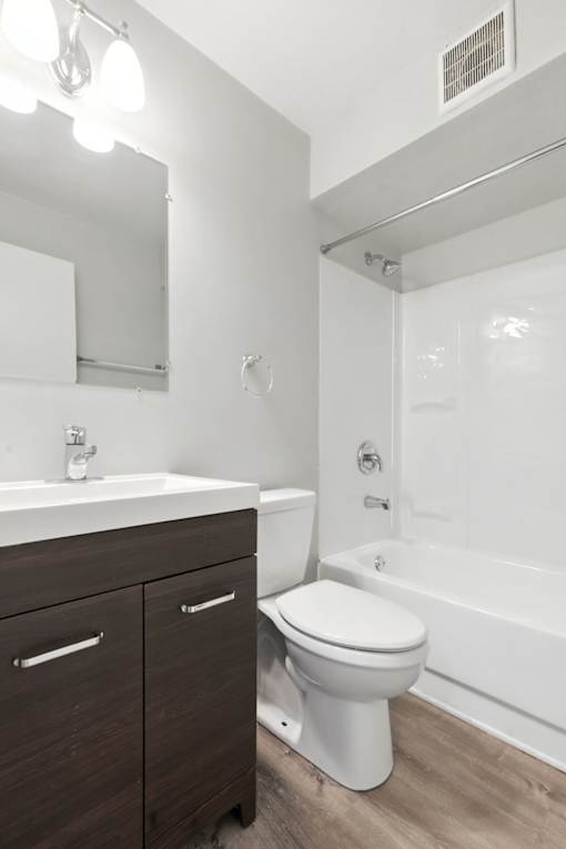 A white toilet sits next to a sink in a modern bathroom.