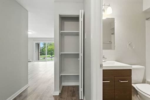 A white bathroom with a large mirror and a white sink.