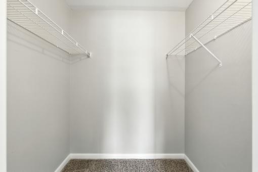 A walk-in closet with a carpeted floor and white walls.