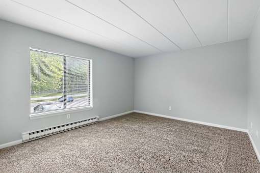 A room with a window and a car parked outside.