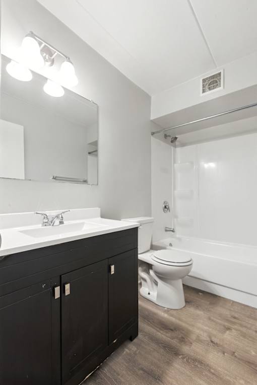 A white sink is on a black countertop in a bathroom.