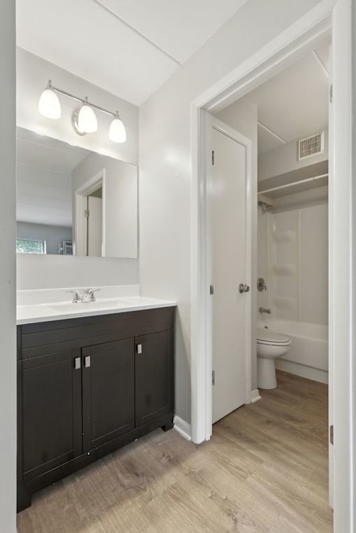 A bathroom with a white sink and black cabinets.
