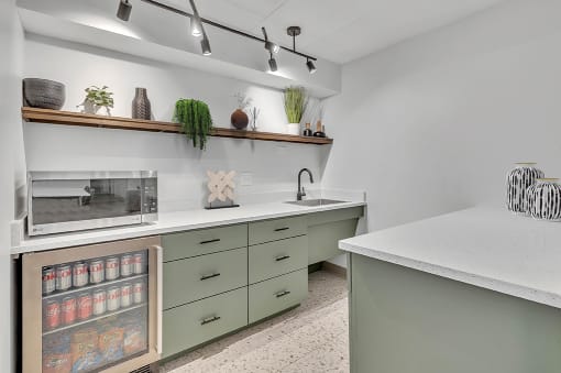 a kitchen with green cabinets and a counter top and a microwave