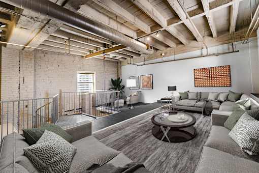 a living room with couches and a table in a loft