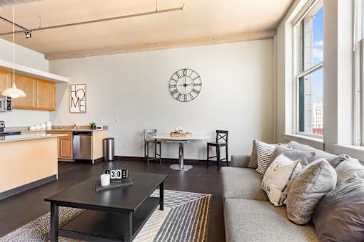 a living room with a couch and a clock on the wall