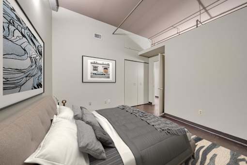 A bedroom with a bed and a picture on the wall.