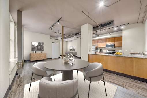 A modern dining room with a round table and chairs.