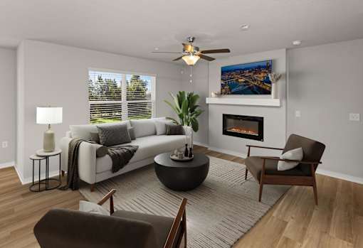 A living room with a fireplace, a couch, a chair, and a potted plant.