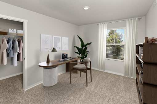 A room with a desk, chair, and a plant.