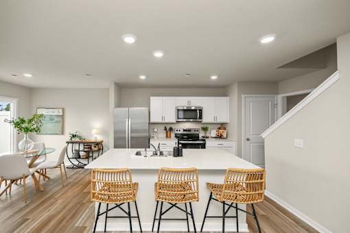 A modern kitchen with a dining table and chairs.