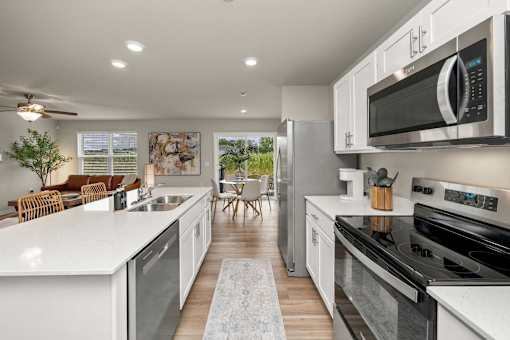 A modern kitchen with white cabinets and stainless steel appliances.