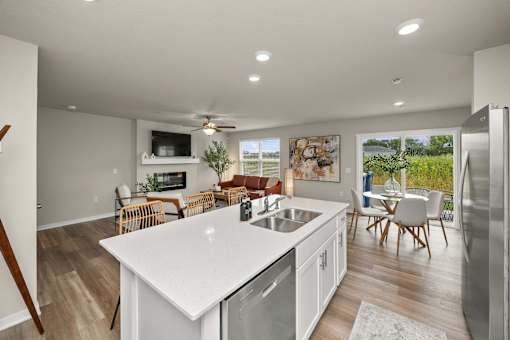 A modern kitchen with white countertops and stainless steel appliances.