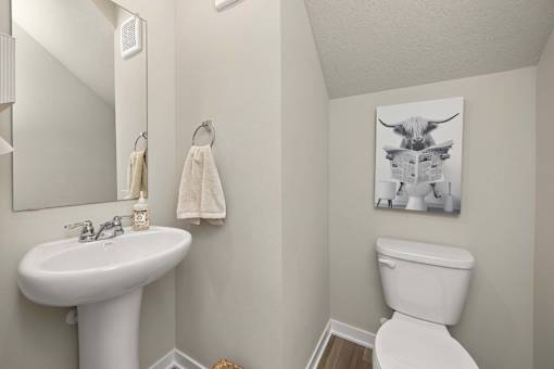 A white toilet sits next to a white sink in a bathroom.