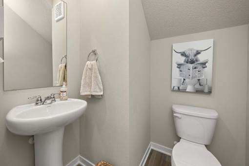A white toilet sits next to a white sink in a bathroom.