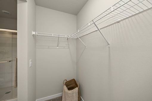 A white closet with a coat hanging on the hook.