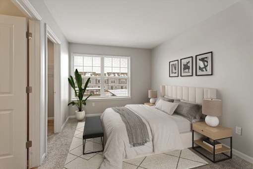 A bedroom with a large bed, a bench, and pictures on the wall.