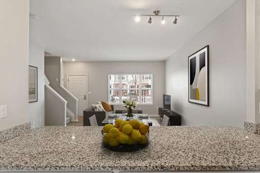 A living room with a marble table and a bowl of lemons on it.