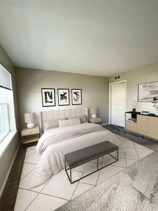 A bedroom with a large bed and a bench in the middle of the room.