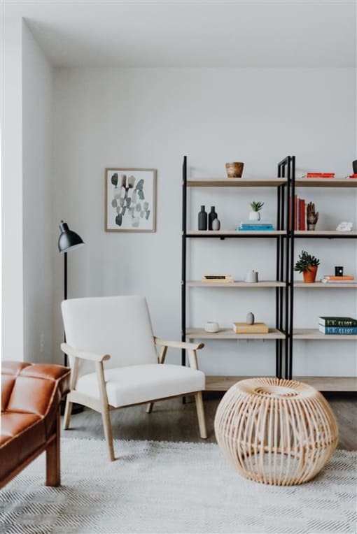 a living room with a book shelf and a chair