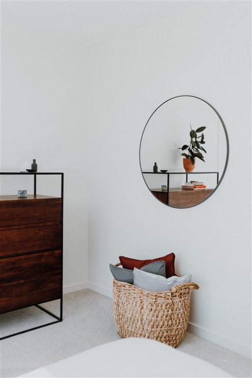 a bedroom with a bed and a mirror on the wall