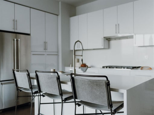 a white kitchen with white cabinets and a white table