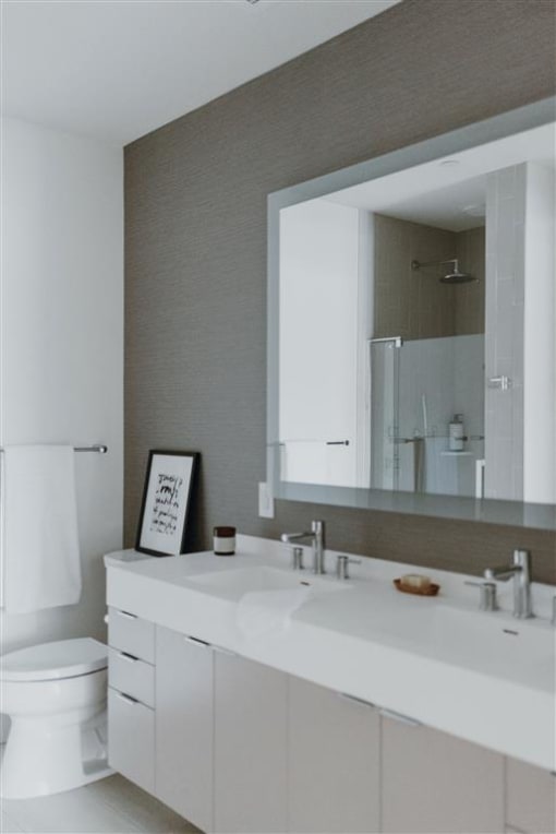 a bathroom with a white toilet and a large mirror