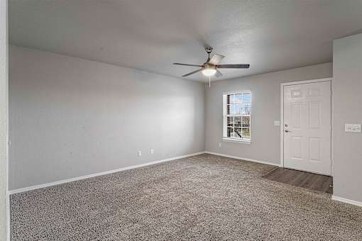 A room with a ceiling fan and a door.