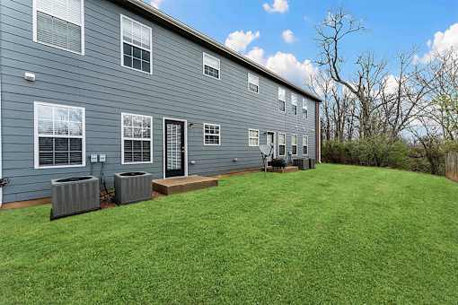 A grey house with a green lawn in front.