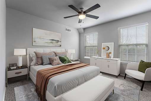 A bedroom with a large bed and a ceiling fan.
