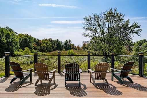 A set of six chairs are arranged on a wooden deck.