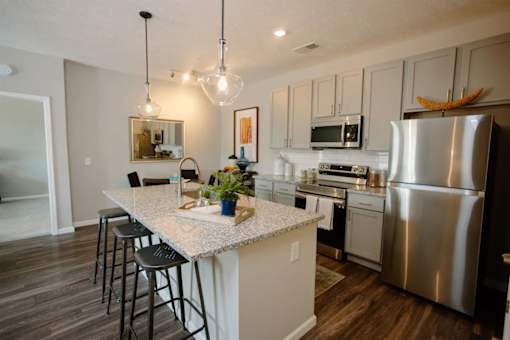 A kitchen with a white island and stainless steel appliances.