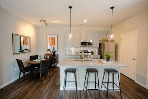 A kitchen with a bar and a dining table.