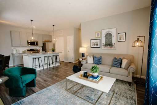 A living room with a white couch and a green chair.