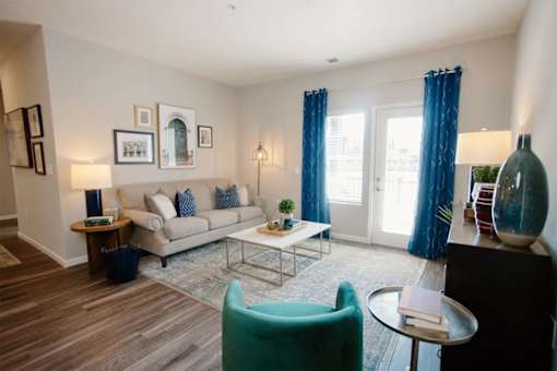 A living room with a couch, chair, and pictures on the wall.