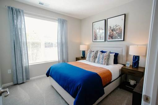 A bedroom with a large bed and two lamps.