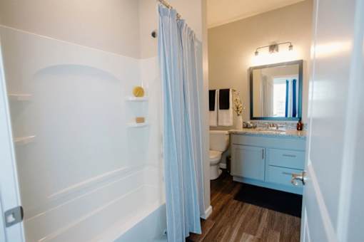 A bathroom with a white tub and a white sink.