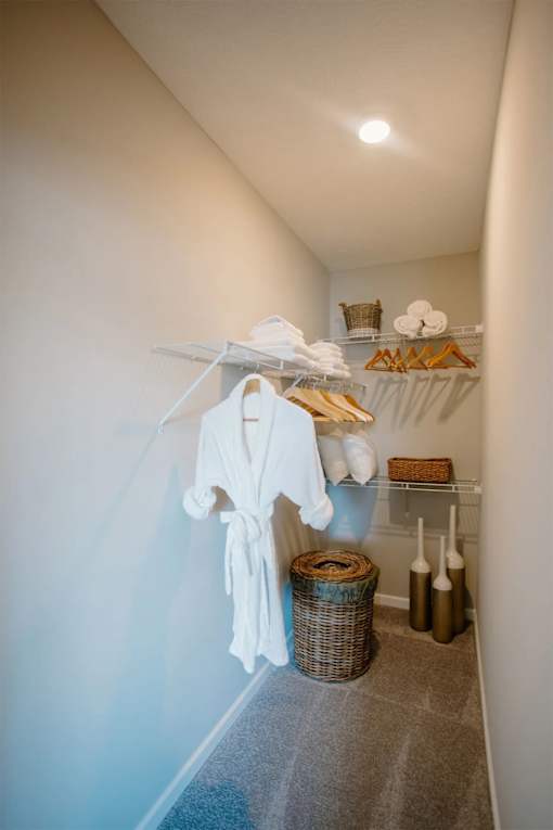 A white robe is hanging on a rack in a hallway.
