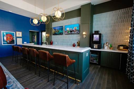 A bar with red chairs and a blue wall.