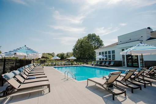 A pool with sun loungers and umbrellas.