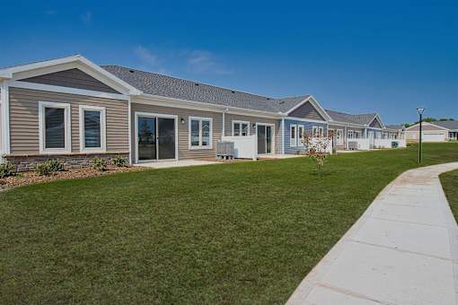 A row of houses with a sidewalk in front.