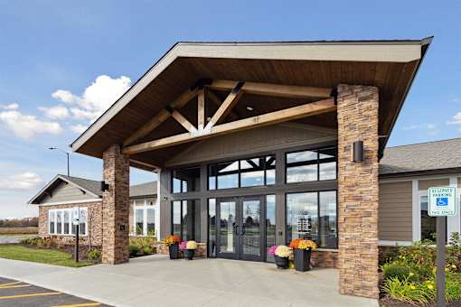 A building with a covered entrance and a sign that says "Welcome to" in front of it.