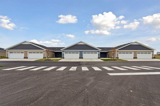 A parking lot with a row of garages in front of a clear blue sky.