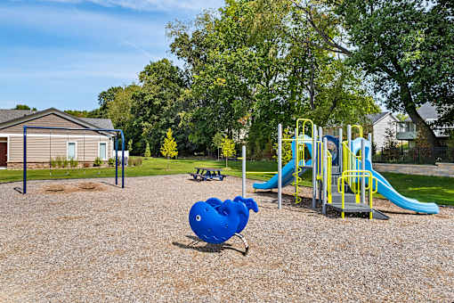 A playground with a blue slide and a yellow and blue play structure.